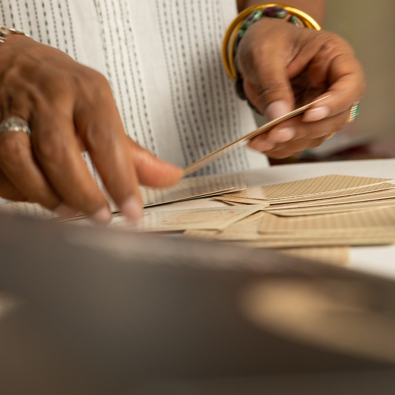 Mains retournant des cartes, illustrant ma mission de guider et d’accompagner.